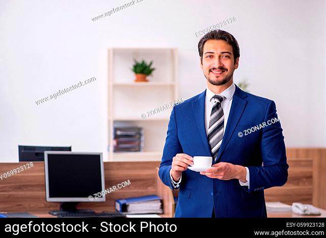 Young employee drinking coffee during break