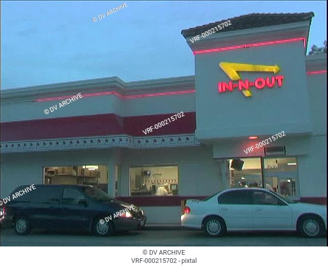 Patrons pick up food at the busy In-and-Out drive through restaurant