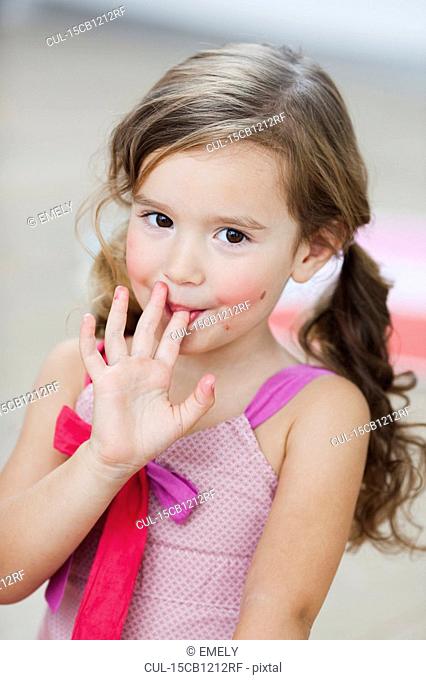 young girl licking her fingers