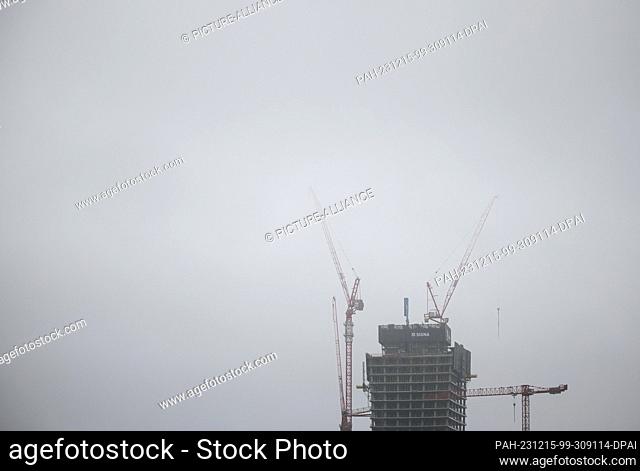 15 December 2023, Hamburg: The cranes over the top of the Elbtower construction site in Hafencity disappear into the fog. At 244