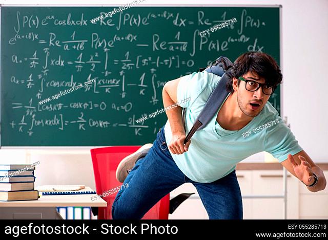 Young male student mathematician in front of chalkboard