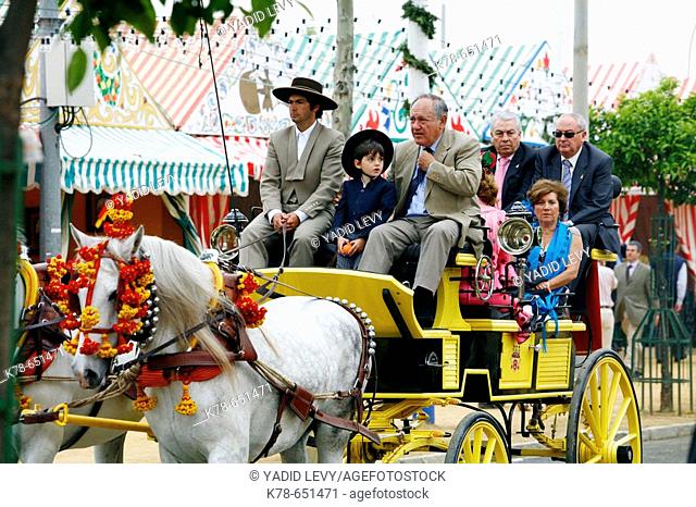 People sitting on a horse drawn carriage at the April Fair, Seville, Spain
