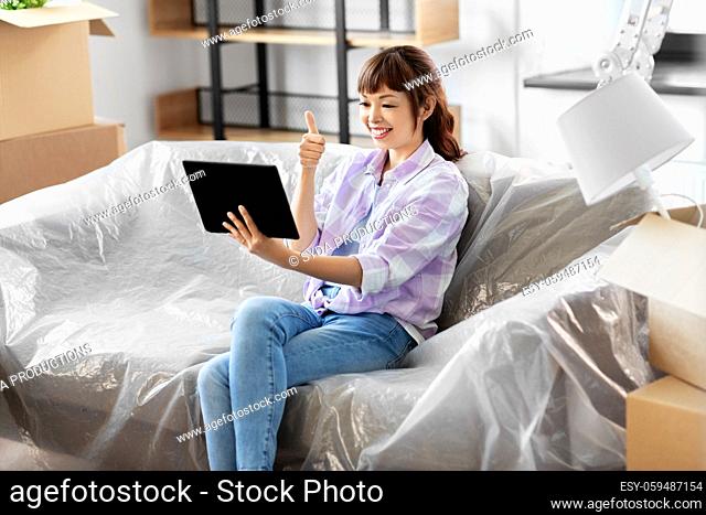 woman with tablet pc having video call at new home