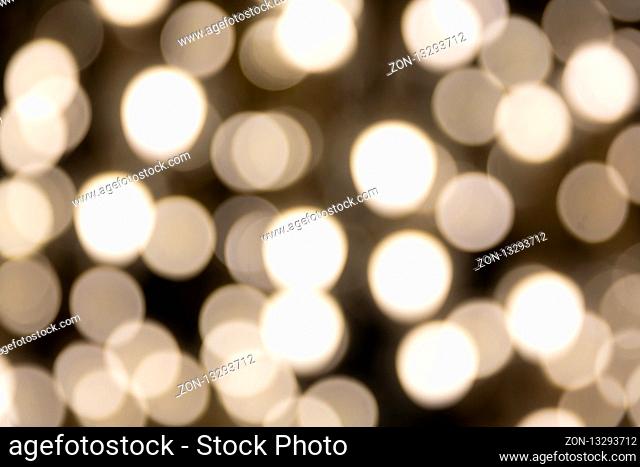 Gold Glitter Background. Yellow blurry lights on black background