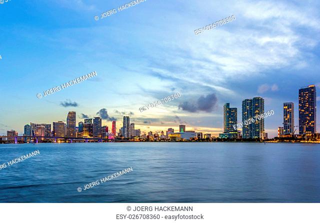 Miami city skyline panorama at night with urban skyscrapers and bridge