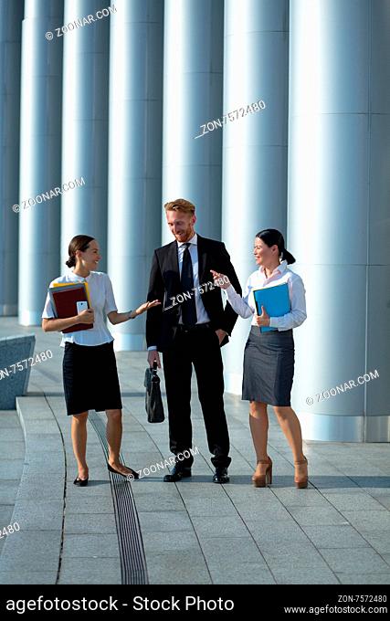 Happy business people discussing problems while walking. Two women persuading man with their opinion