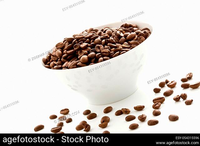 photo of delicious coffee beans inside a white bowl on white isolated background