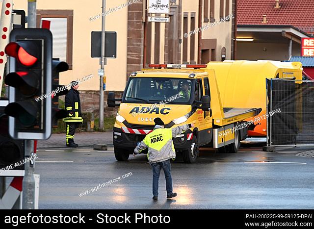 25 February 2020, Hessen, Volkmarsen: A tow truck takes the car away from the scene of the crime. The day before, a man raced into a carnival parade here and...