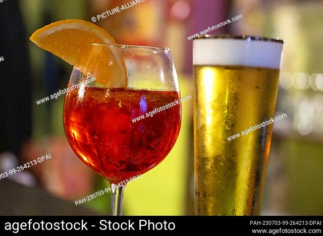 PRODUCTION - 01 July 2023, Berlin: In a bar, a glass of Aperol Spritz and a glass of non-alcoholic beer are on the counter