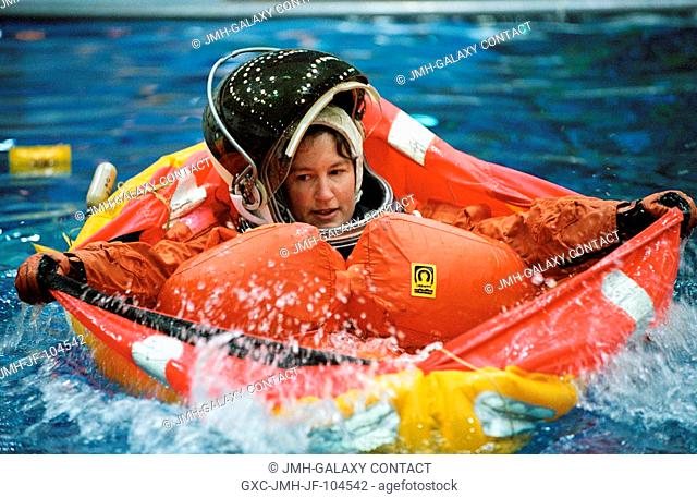 Astronaut Laurel B. Clark, STS-107 mission specialist, floats in a small life raft during an emergency egress training session in the Neutral Buoyancy...