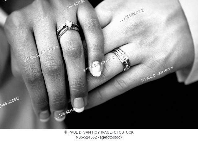 Bride and groom with wedding bands and hands crossed