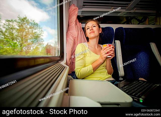 Young woman traveling by train (landscape moving fast behind the window (<--- motin blurred image)