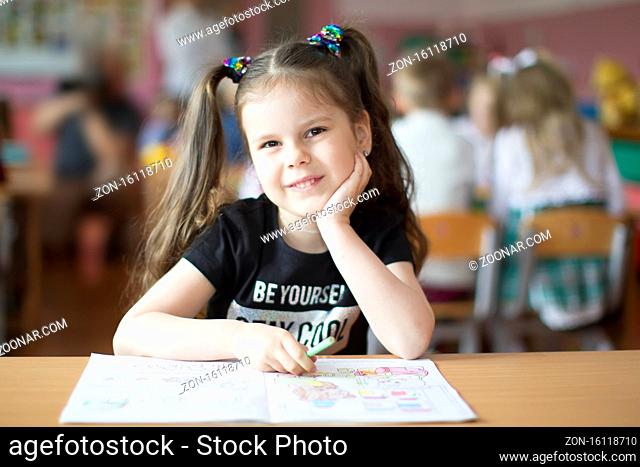 Belarus, the city of Gomil, May 10, 2019. Open day in kindergarten. Preschooler girl with a book. First-grader. Portrait of a kindergarten graduate