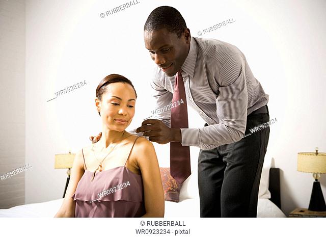 Man doing up a womans necklace clasp
