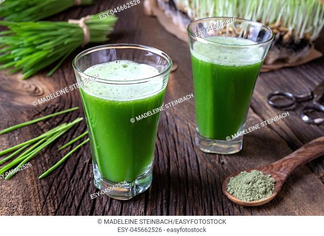 Two glasses of barley grass juice with freshly harvested blades