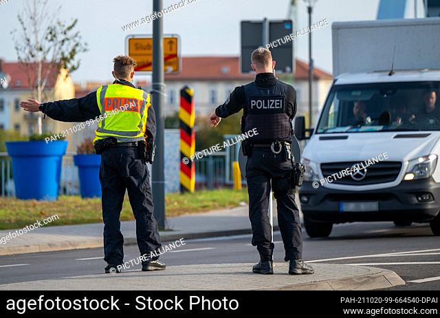 20 October 2021, Brandenburg, Frankfurt (Oder): Two police officers stop a vehicle on the border bridge between Germany and Poland to check for illegal entrants