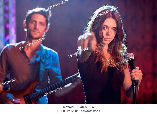 Portrait of female singer with male guitarist performing at nightclub