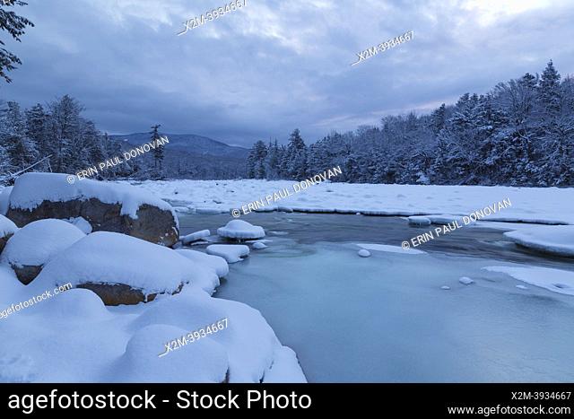 East Branch of the Pemigewasset River in Lincoln, New Hampshire covered in snow at sunrise on a cold and cloudy winter morning