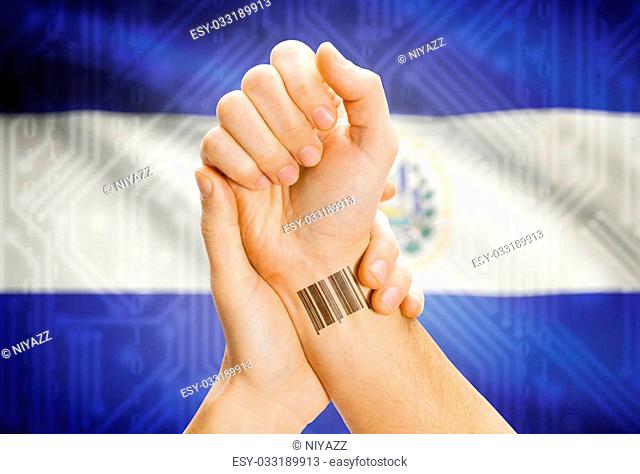 Barcode ID number on wrist of a human and national flag on background - El Salvador