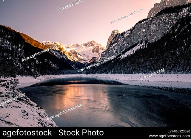 Spectacular winter view of lake Gosau, Gosausee with fresh snow on majestic mountains, pines forest and reflection on the lake