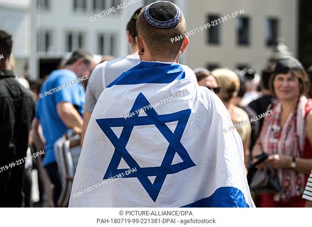 19 July 2018, Germany, Bonn: A man demonstrating against anti-semitism on the market square and wrapped in an Israeli flag