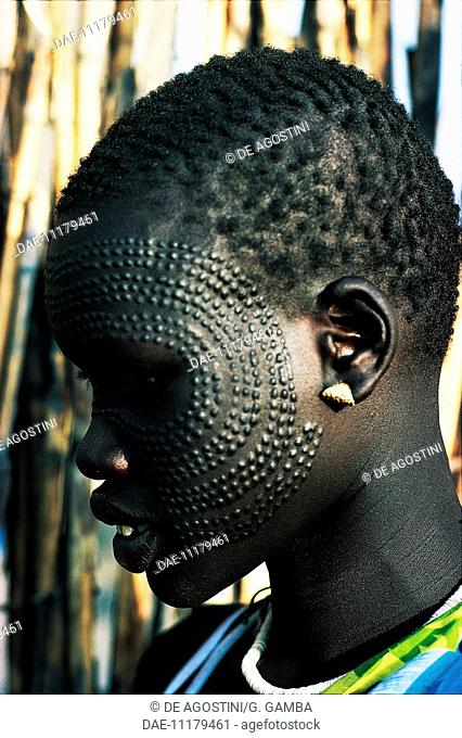 Young Nuer woman with ornamental scarification on her face, South Sudan