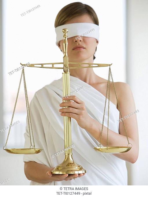 Blindfolded woman holding scales