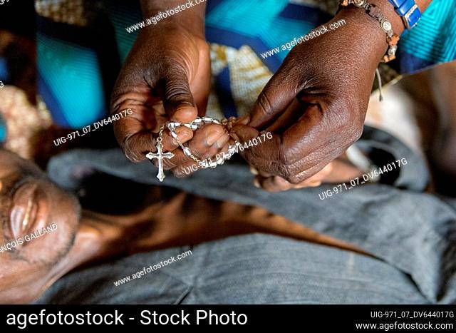 Sister Marie Stella offers a rosary to a newly baptised 42-year-old cathechumen dying of AIDS. Vivre dans l'Esperance (living with hope) NGO