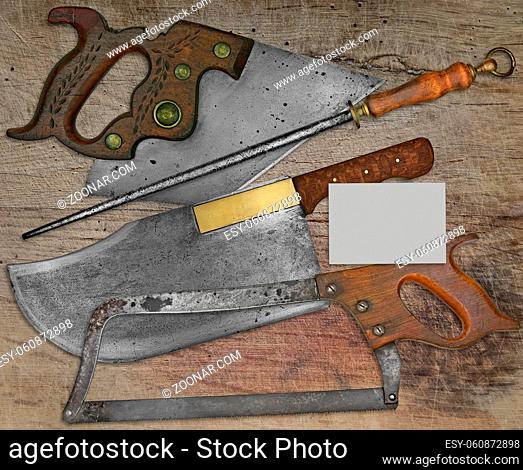 vintage butcher shop tools over stained wooden table, space on business card for your text