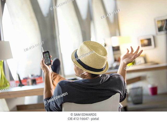 Casual businessman talking on cell phone with feet up on desk