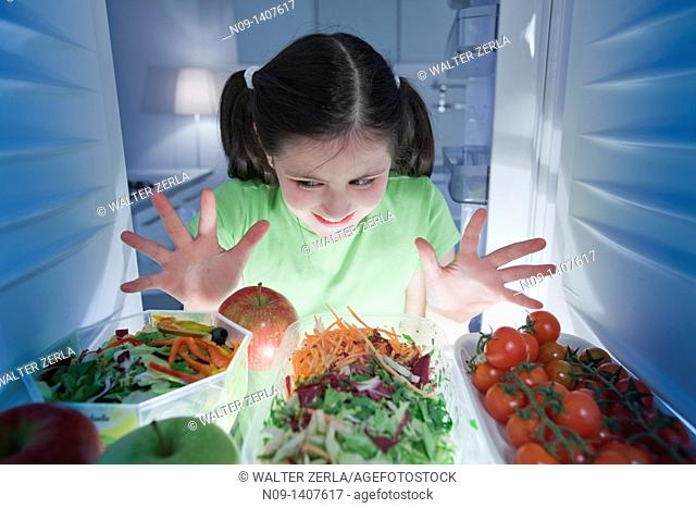 Girl looks in the fridge