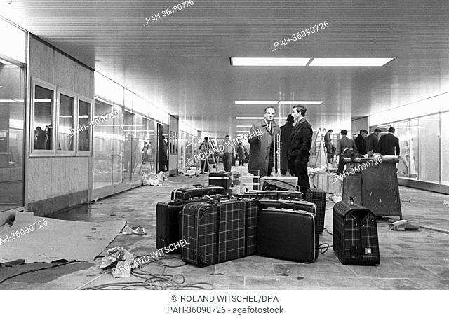 Tradesmen unpack their ware on 19 November 1963, with which they want to promote their products in the display cases of glass in the new pedestrian subway of...