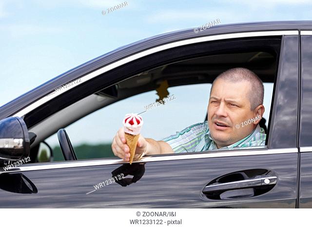 Man sitting in a car offers ice cream