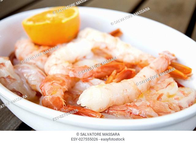 fresh and raw king prawns with orange sauce
