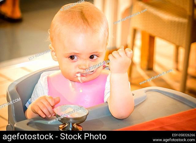 Little boy sitting in a highchair in a cafe inside a shopping mall