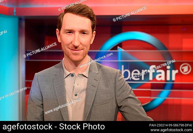 13 February 2023, North Rhine-Westphalia, Cologne: The presenter Louis Klamroth poses in his program of the ARD talk show "" Hart aber Fair "" in front of the...