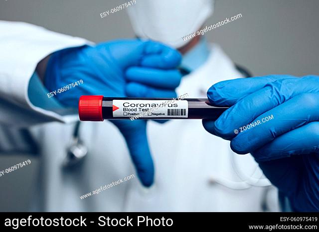 Doctor wearing respiratory mask and holding the Coronavirus Covid-19 blood sample