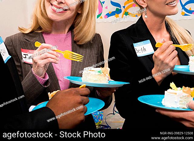 Four office workers eating cake