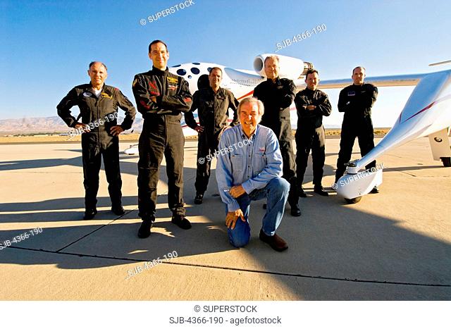 The great aircraft designer and builder Burt Rutan kneels in front of White Knight One along with his six incredible test pilots