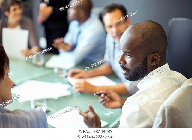 Businessman talking to colleague during business meeting in conference room