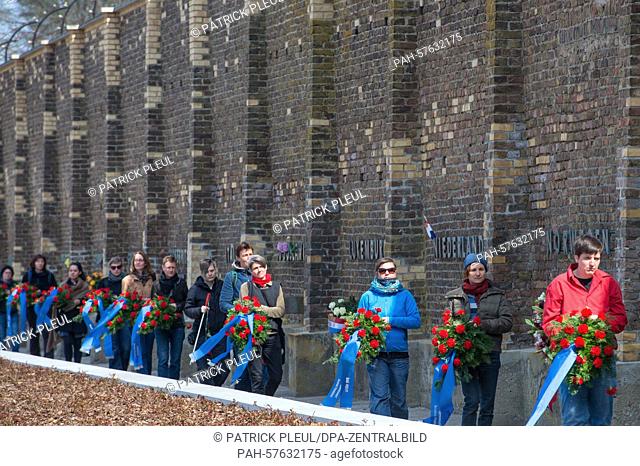 Women carry wreaths to the 'Wall of Nations' during the memorial ceremony on ocassion of the 70th anniversary of the liberation of former concentration camp...