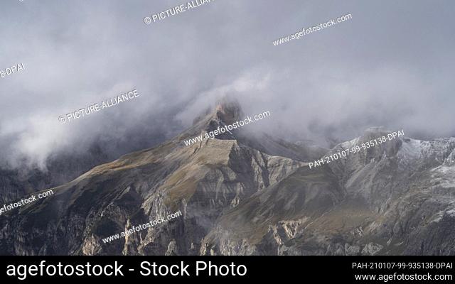 30 September 2017, Austria, Drei Zinnen: View of a mountain peak surrounded by clouds north of the Three Peaks (Italy). The mountain range belongs to the Sesto...