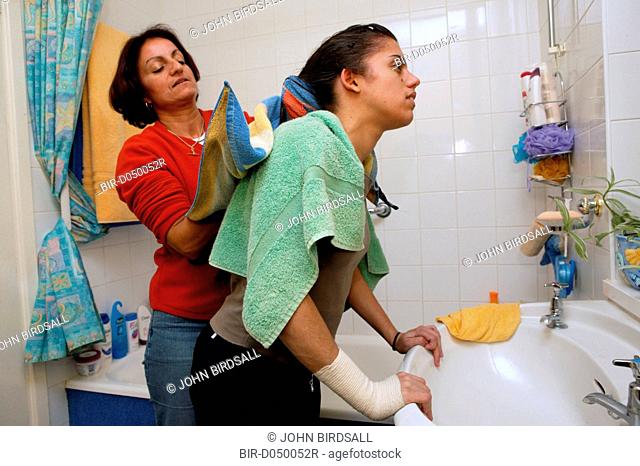 Single parent helping her daughter dry her hair with a towel