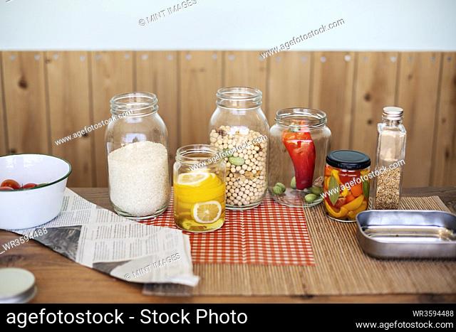 Close up of a selection of foods and condiments in glass jars in a farm shop