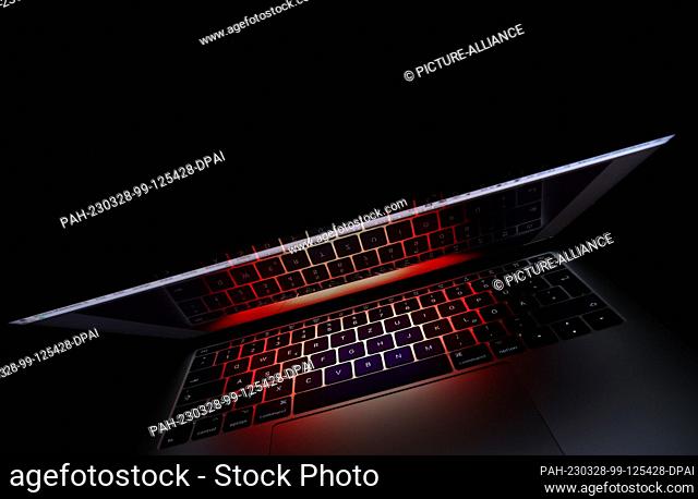 28 March 2023, Bavaria, Kempten: ILLUSTRATION - The keyboard of a laptop is reflected in its screen (recording with zoom effect)