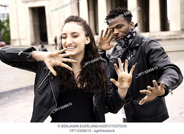 mixed race couple with dirty hands at street in city, in Munich, Germany