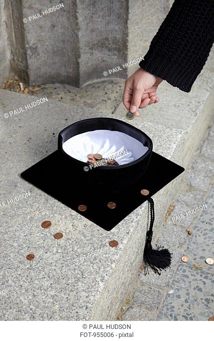 Man dropping coin into mortarboard