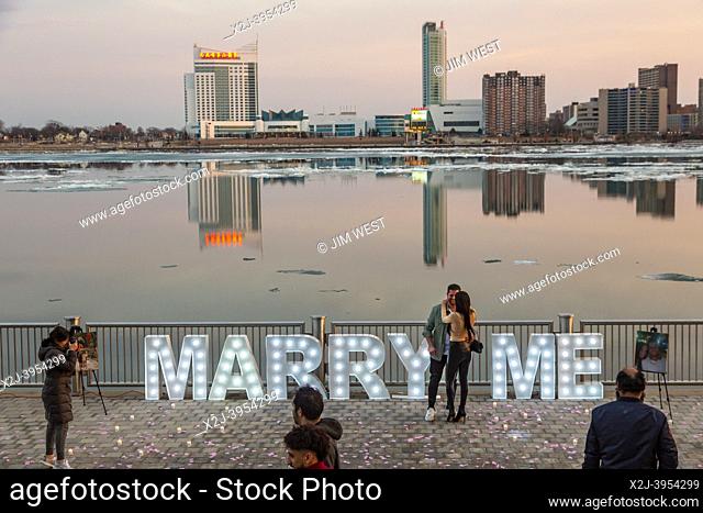 Detroit, Michigan - A happy couple celebrates along the Detroit Riverwalk after the man's public marriage proposal was accepted
