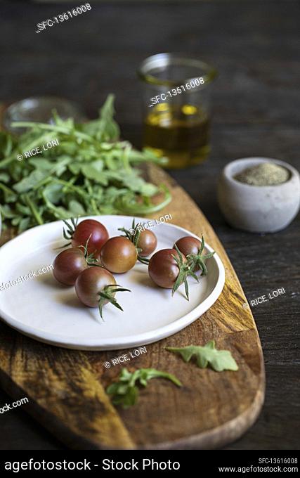 Cherry tomatoes and rocket on a wooden board