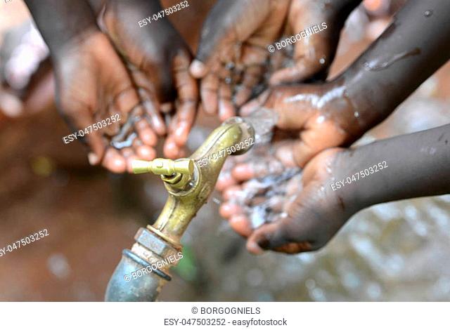 Hands of African Children Cupped under Tap Drinking Water Malnutrition. Hands of African black boys and girls with water pouring from a tap